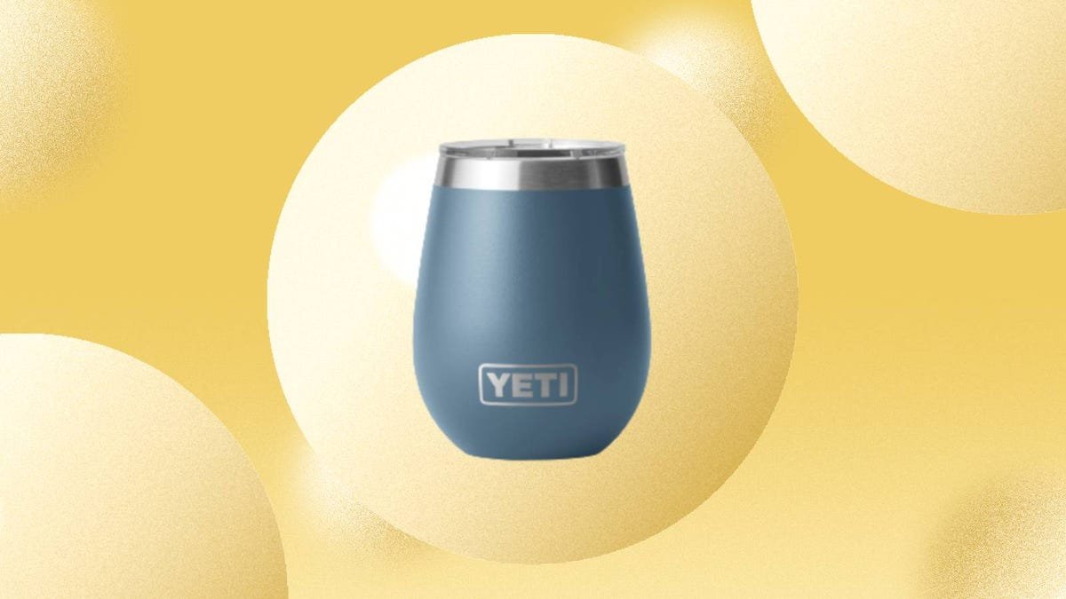 A Yeti Rambler 10 ounce wine tumbler with Magslider lid is displayed against a yellow background.