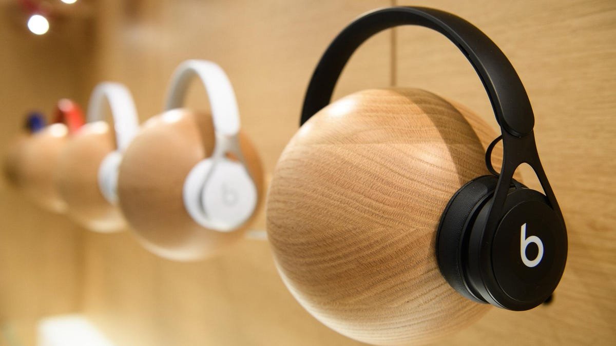 beats headphones resting on wooden ball model on a wall