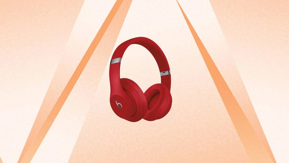 A pair of red Beats headphones against an orange background.