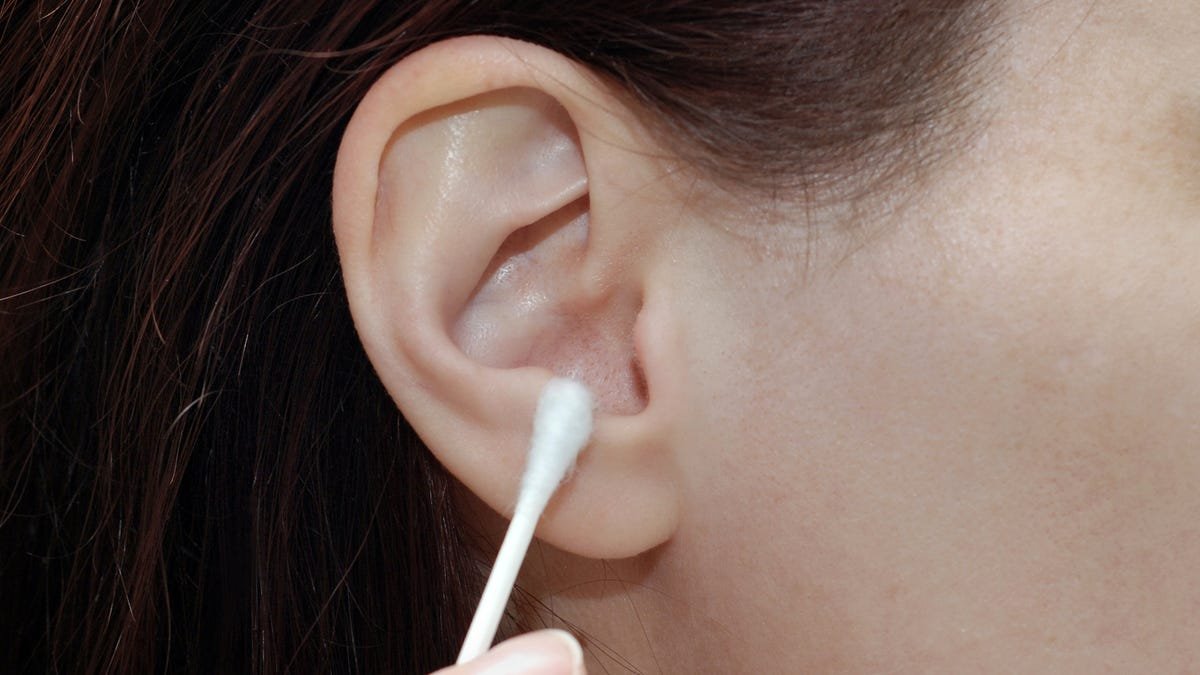 A cotton swab on an ear.