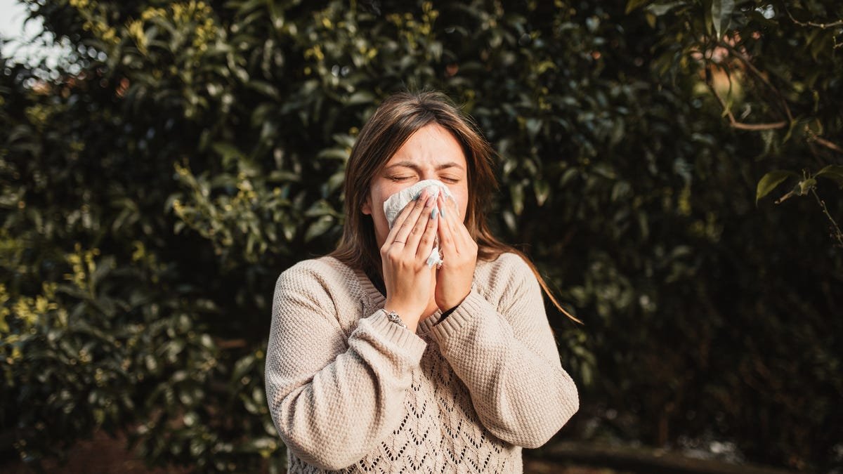 Woman blowing her nose into a handkerchief.