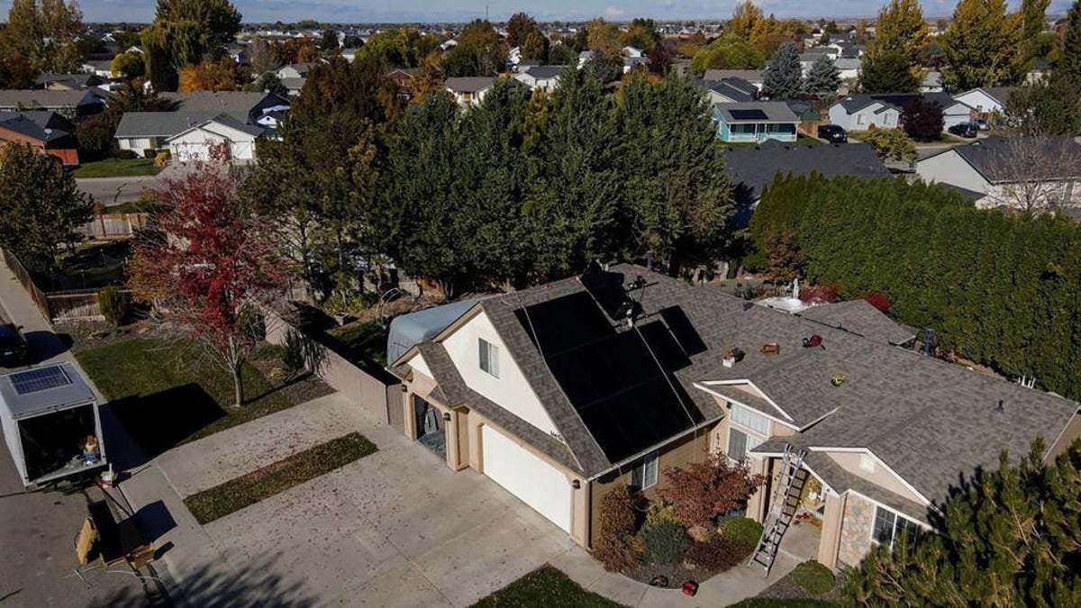 Installers putting solar panels on a home in Idaho.